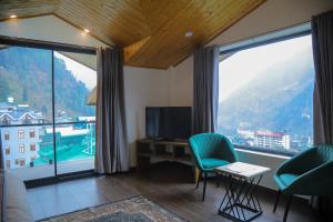 a room with a large window with a desk and chairs at HOGS Panorama - Manali in Manāli