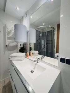 a white bathroom with a sink and a mirror at ApartamentySnu, Apartament Nad Potokiem in Radom