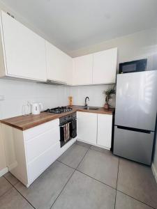 a kitchen with white cabinets and a white refrigerator at ApartamentySnu, Apartament Nad Potokiem in Radom +5 photos