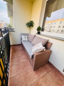 a couch sitting on a balcony with a window at ApartamentySnu, Apartament Nad Potokiem in Radom