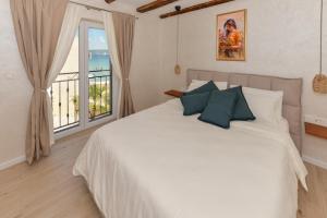 a bedroom with a large white bed with a window at Magna in Dobropoljana