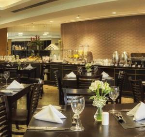 a restaurant with tables and chairs and a bar at Hotel & Residence Alphaville in Barueri