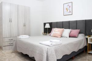 a bedroom with a large bed with white and pink pillows at VL Apart in Villa Regina