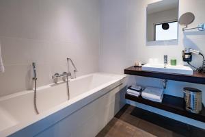 a bathroom with a tub and a sink at Hotel Bella Ciao in Harderwijk +25 photos