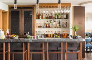 a bar with bar stools and glasses on the wall at Malibu Beach Inn in Malibu