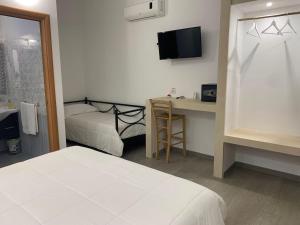 a bedroom with a bed and a desk with a television at Villa Padula in Sogliano Cavour