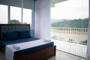 a bedroom with a bed and a large window at The Cliff Kandy in Gonawatta