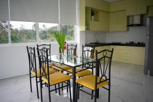 a dining room with a glass table and chairs at The Cliff Kandy in Gonawatta
