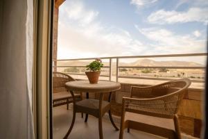 a table and chairs on a balcony with a view at Theban Hills Hotel, Luxor in ‘Ezbet Abu Ḥabashi