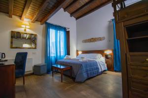 a bedroom with a bed and a table and a mirror at Hotel La Plumeria in Cefalù