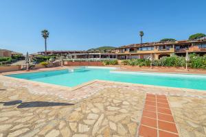 a swimming pool in a resort with a building in the background at Villaggio Marineledda in Santa Marinella