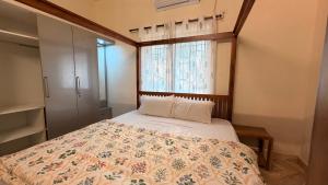 a small bedroom with a bed with a window at Athiratha Living in Malpe