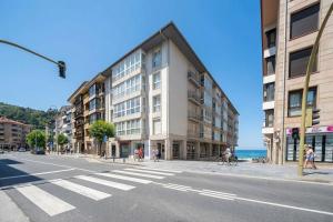 a building on the side of a street next to the ocean at Bañeru Zarautz Centro - Sol, playa y confort, todo a un paso in Zarautz