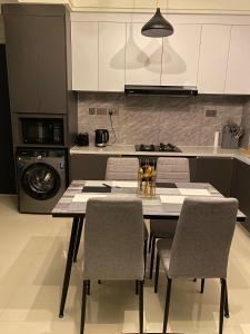 a kitchen with a table with chairs and a stove at Luxeliving Homes in Nairobi
