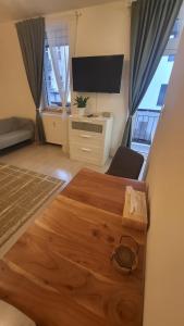 a living room with a tv and a wooden table at Downtown Boho Botanico in Brno