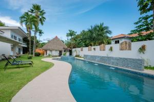 a swimming pool in a yard next to a house at Bambu Beach Haus Coronado in Las Lajas
