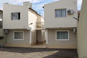a white house with two stories and a balcony at VL Apart in Villa Regina