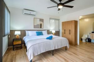 a bedroom with a large bed with a blue pillow on it at Bambu Beach Haus Coronado in Las Lajas +36 photos
