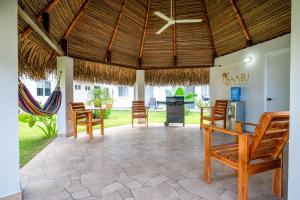 a living room with chairs and a ceiling at Bambu Beach Haus Coronado in Las Lajas
