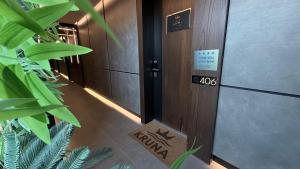a hallway in a building with a sign on the door at KRUNA 406 Luxury Sea View Apartment with Parking, Minibar, Spa & Beach - Includes 2 Complimentary Non-Alcoholic Beach Drinks & Welcome Gift in Budva