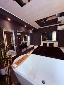a large bathroom with a bath tub and a bed at Ama Suite Romantic Spa in Bologna