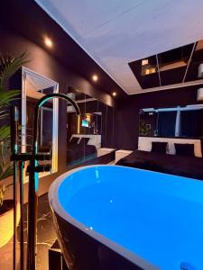 a bathroom with a tub with a bed in the background at Ama Suite Romantic Spa in Bologna