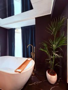 a bathroom with a white bath tub and a plant at Ama Suite Romantic Spa in Bologna +8 photos