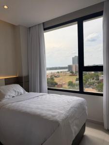 a bedroom with a bed and a large window at Milord Suites & Apartments in Encarnación