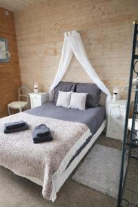 a bedroom with a bed with a canopy at L'Âme du Gourmand in Pontorson