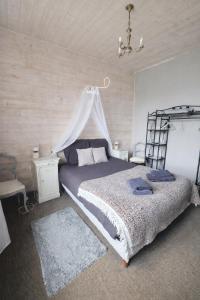 a bedroom with a large bed and a chandelier at L'Âme du Gourmand in Pontorson