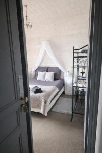 a bedroom with a bed with a canopy at L'Âme du Gourmand in Pontorson