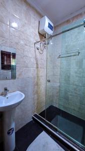 a bathroom with a glass shower and a sink at The Vistana 4Bedroom Pearly Gate Estate Ikota VGC Lekki in Igboshere +33 photos