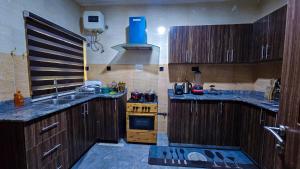 a kitchen with wooden cabinets and a sink and a stove at The Vistana 4Bedroom Pearly Gate Estate Ikota VGC Lekki in Igboshere
