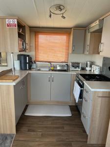 a small kitchen with a sink and a stove at Maneight Retreat with Hot tub in New Cumnock