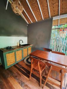 a dining room with a wooden table and a kitchen at Seenau House Bali in Selemadeg +11 photos
