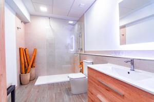 a bathroom with a sink and a tub and a toilet at EDomus Medellin 1485 Suites in Don Benito