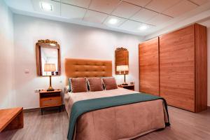 a bedroom with a large bed and a mirror at EDomus Medellin 1485 Suites in Don Benito