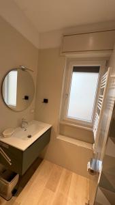 a bathroom with a sink and a mirror and a window at Affittacamere Nonna Maria in Foggia +6 photos