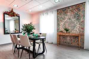 a dining room with a table and chairs and a mirror at EDomus Medellin 1485 Suites in Don Benito +39 photos