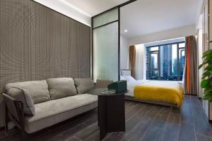 a living room with a couch and a bed at ROLA&RICCI Hotel Chengdu East Branch in Chengdu
