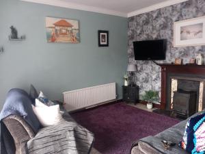 a living room with a couch and a fireplace at Home Comforts in Castleisland