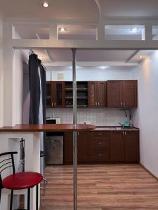 a kitchen with wooden cabinets and a table in a room at Студія Люкс з терасою в центрі міста in Kryvyi Rih