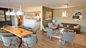 a dining room and living room with a table and chairs at Les Geais - Marevalande in Sainte-Maxime