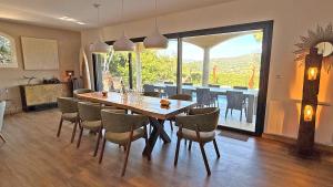 a dining room with a wooden table and chairs at Les Geais - Marevalande in Sainte-Maxime
