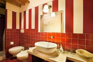 a bathroom with a sink and a toilet and a mirror at Bosco Ai Marzi - 2 Apartments with shared pool in Poggibonsi