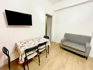a room with a table and a chair and a television at Casa Vacanza Regina in Scalea