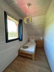 a small room with a bed and a window at Morze Lubiatowo in Lubiatowo