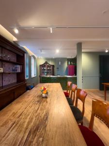 a dining room with a wooden table and chairs at 3sine - Ihr besonderer Gasthof im Bahnhof Deisenhofen in Oberhaching +32 photos