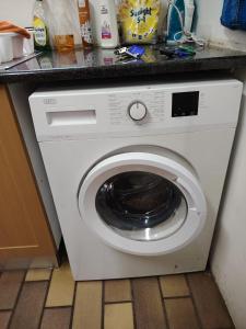 a white washing machine sitting under a counter at Pennington Holiday Cottages in Pennington