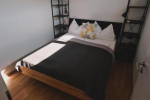 a bedroom with a bed with black and white pillows at Pannolio Beach Boutique Apartment in Eisenstadt